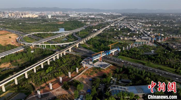 航拍正在建設(shè)的跨越成都繞城高速公路連續(xù)梁施工現(xiàn)場(chǎng)，旁邊依次為已運(yùn)營(yíng)的成渝高速鐵路和機(jī)場(chǎng)高速公路?！⒅铱?攝