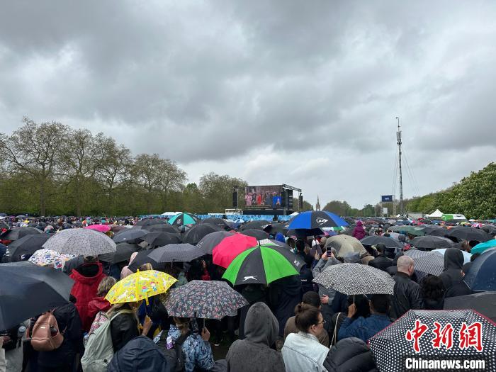 當?shù)貢r間5月6日，英國國王查爾斯三世的加冕儀式舉行。民眾雨中觀看儀式。　歐陽開宇 攝