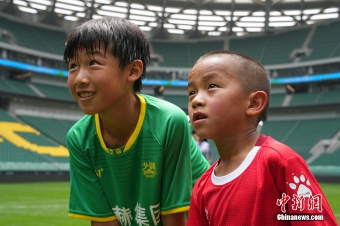 圖為北京國安小球員陳小北和7歲的俄金仁增在一起觀看場內(nèi)播放的紀(jì)錄片。<a target='_blank' href='/' _fcksavedurl='/'><p  align=