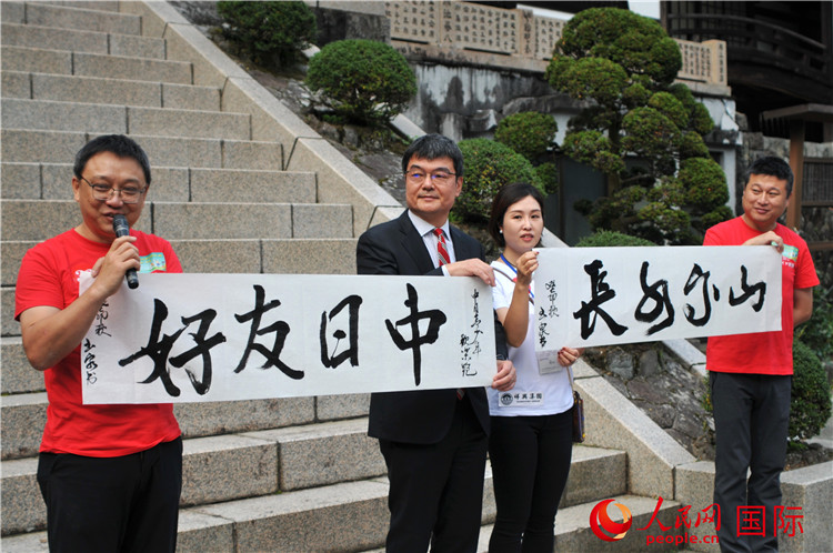 東京中國文化中心主任羅玉泉展示其為本次活動書寫的題詞“中日友好，山高水長”。人民網(wǎng) 蔣曉辰攝