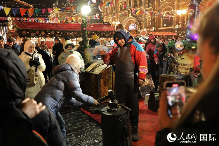 游客在新年集市上體驗(yàn)制作紀(jì)念幣。人民網(wǎng)記者 隋鑫攝