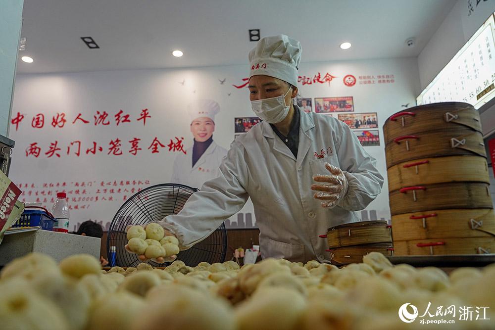 3月31日，在浙江省嵊州市甘霖鎮(zhèn)，嵊州小吃從業(yè)者沈紅平把蒸熟的小籠包晾涼，打包冷藏售賣。人民網(wǎng) 章勇濤攝