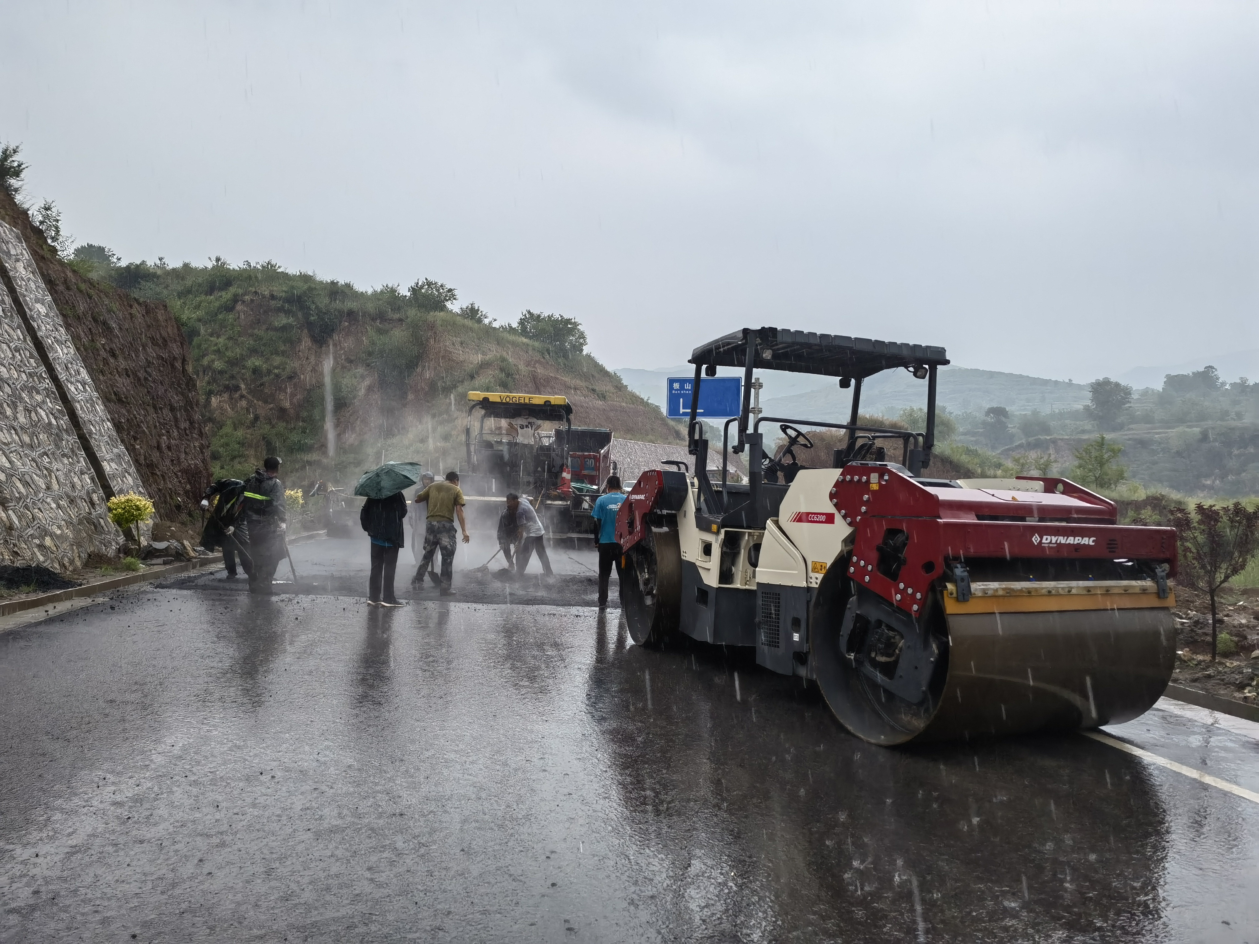 路橋工人在大雨中搶修道路。李華英 攝