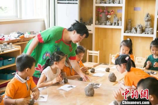 圖為劉雪玲正在給幼教中心的孩子上泥塑課?！＄娦?攝