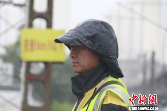 蘭州西工務(wù)段蘭州線路車間防護(hù)員雨中巡查?！⊥豕廨x 攝