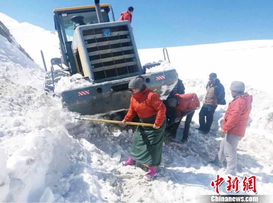 圖為普布卓瑪(左一)與養(yǎng)護(hù)工人一起抗擊雪災(zāi)，搶險(xiǎn)保通?！“⒗锏貐^(qū)公路養(yǎng)護(hù)段供圖 攝