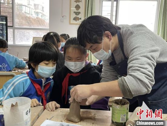 圖為西寧市勞動路小學(xué)教師賈煜與學(xué)生一起制作陶藝?！≈苋鸪阶?攝