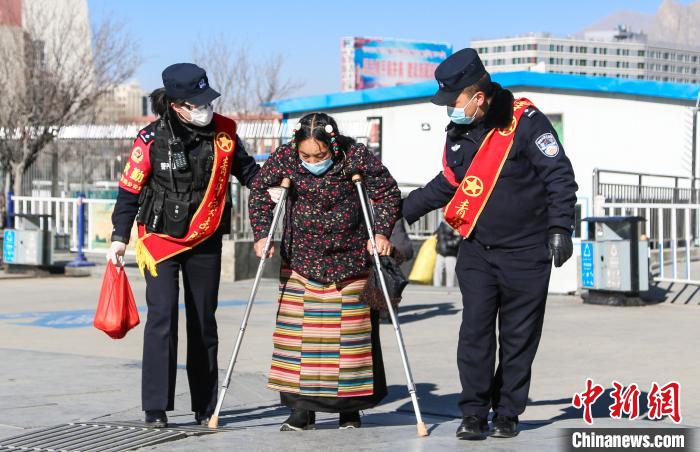 圖為拉薩鐵路公安民警幫助老人進(jìn)站乘車?！『铲i 攝