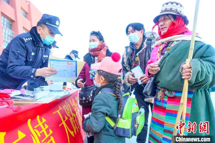 圖為拉薩鐵路公安民警向旅客發(fā)放乘車安全宣傳資料?！↑S飛 攝