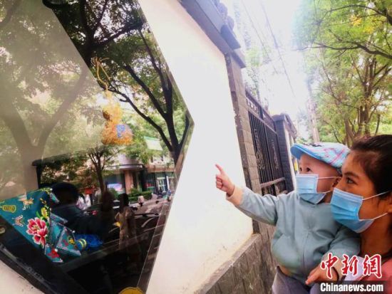 圖為蘭州市民在街頭觀賞刺繡和刻葫蘆的非遺展示。(資料圖) 史靜靜 攝