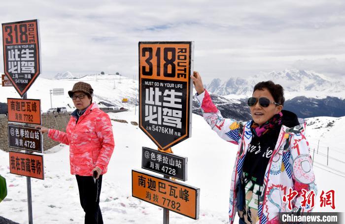 圖為5月14日，西藏林芝色季拉山觀景臺，游客與南迦巴瓦峰合影?！±盍?攝