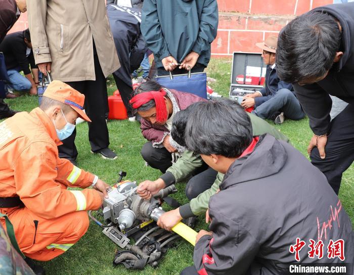 圖為森林消防員為護林員講解滅火裝備的使用方法?！〔际猩窒乐ш?供圖