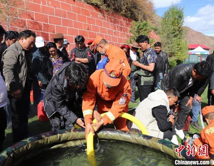 圖為森林消防員為護林員講解滅火裝備的使用方法?！〔际猩窒乐ш?供圖