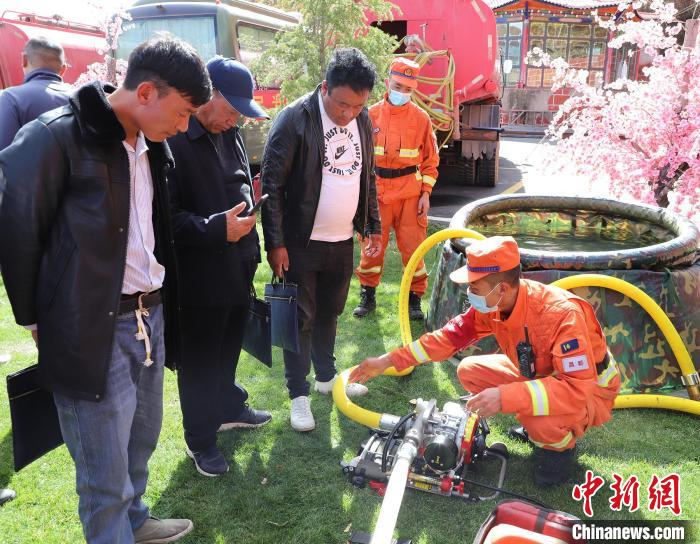 圖為森林消防員為護林員講解滅火裝備的使用方法?！〔际猩窒乐ш?供圖