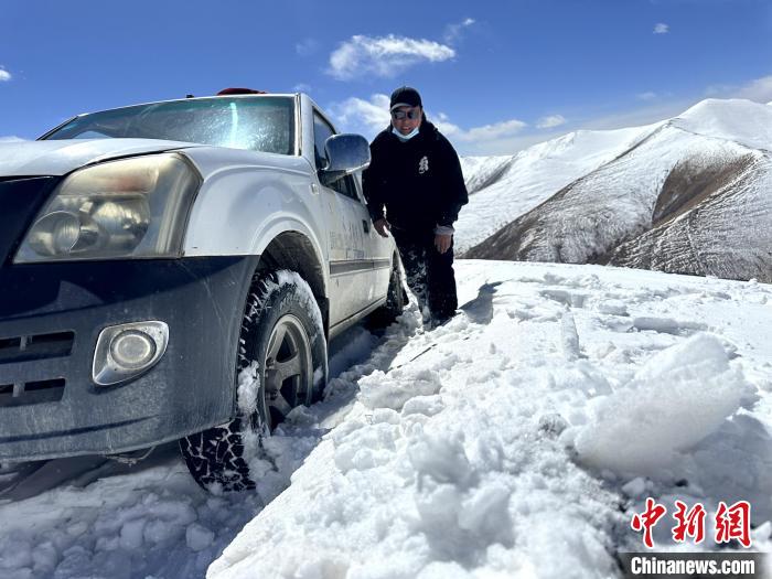 圖為生態(tài)管護人員準備在雪地推車?！《“瓦_杰 攝