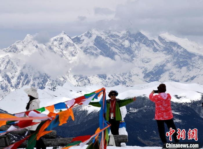 圖為5月14日，西藏林芝色季拉山觀景臺(tái)，游客與南迦巴瓦峰合影?！±盍?攝