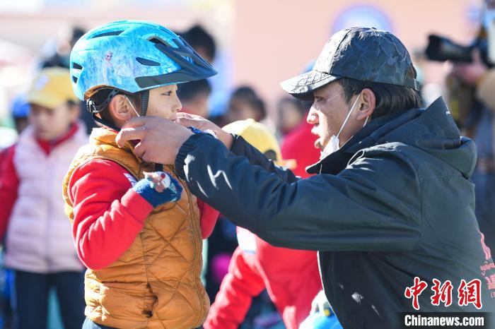 圖為拉薩市實驗幼兒園孩子在教練的幫助下穿戴頭盔。　何蓬磊 攝