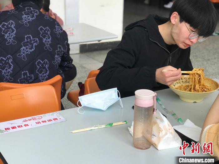 3月17日，西藏大學(xué)學(xué)生正在學(xué)校食堂用餐，餐桌上寫著“按需取餐，切勿浪費(fèi)”。　冉文娟 攝