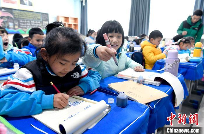 3月14日，西藏拉薩市第一小學(xué)一年級(jí)六班學(xué)生白瑪朗珍(圖左)在藏語(yǔ)文課上書寫藏文?！±盍?攝