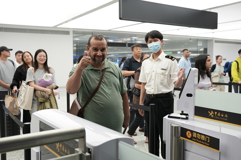 杭州海關所屬杭州蕭山機場海關關員引導國外旅客通過一體化智能閘機進行通關。周雨亮攝