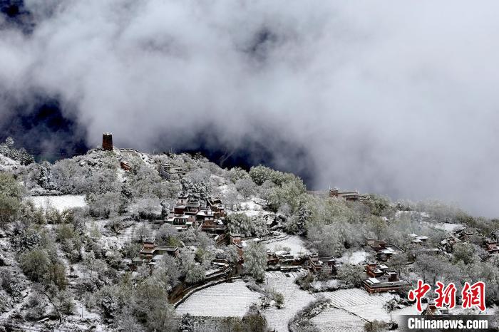 雪后的藏寨和碉樓構(gòu)成美麗的雪景?！〗党鯘衫?攝