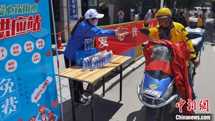 圖為近日，西藏自治區(qū)青年志愿者協(xié)會(huì)志愿者在拉薩街頭向快遞員送水。西藏自治區(qū)青年志愿者協(xié)會(huì) 供圖