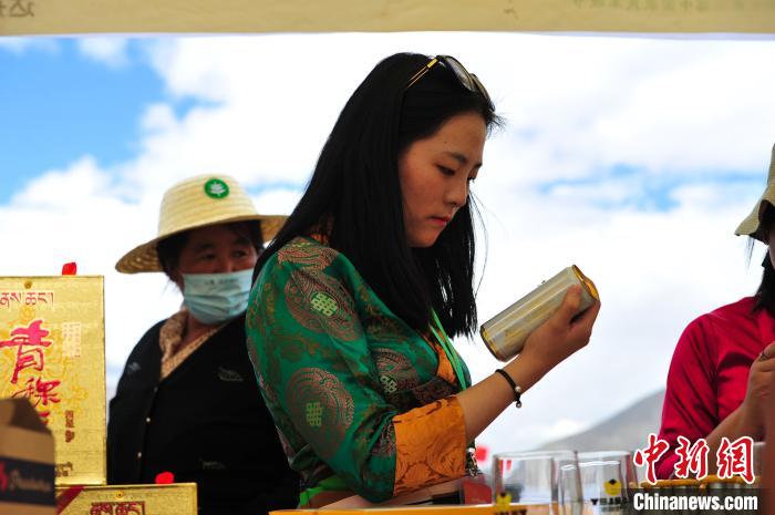 圖為拉薩市民在特色農(nóng)畜產(chǎn)品展示展銷會(huì)上選購(gòu)商品?！垈?攝