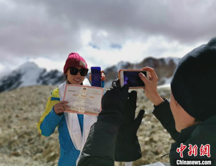 圖為5日，登頂洛堆峰的登山者獲得西藏自治區(qū)登山協(xié)會(huì)頒發(fā)的登頂證明?！垈?攝