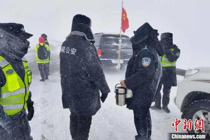 強(qiáng)降雪后，西藏安多縣警方在國(guó)道109線唐古拉山段開展除雪保通工作。　安多縣公安局 供圖 攝