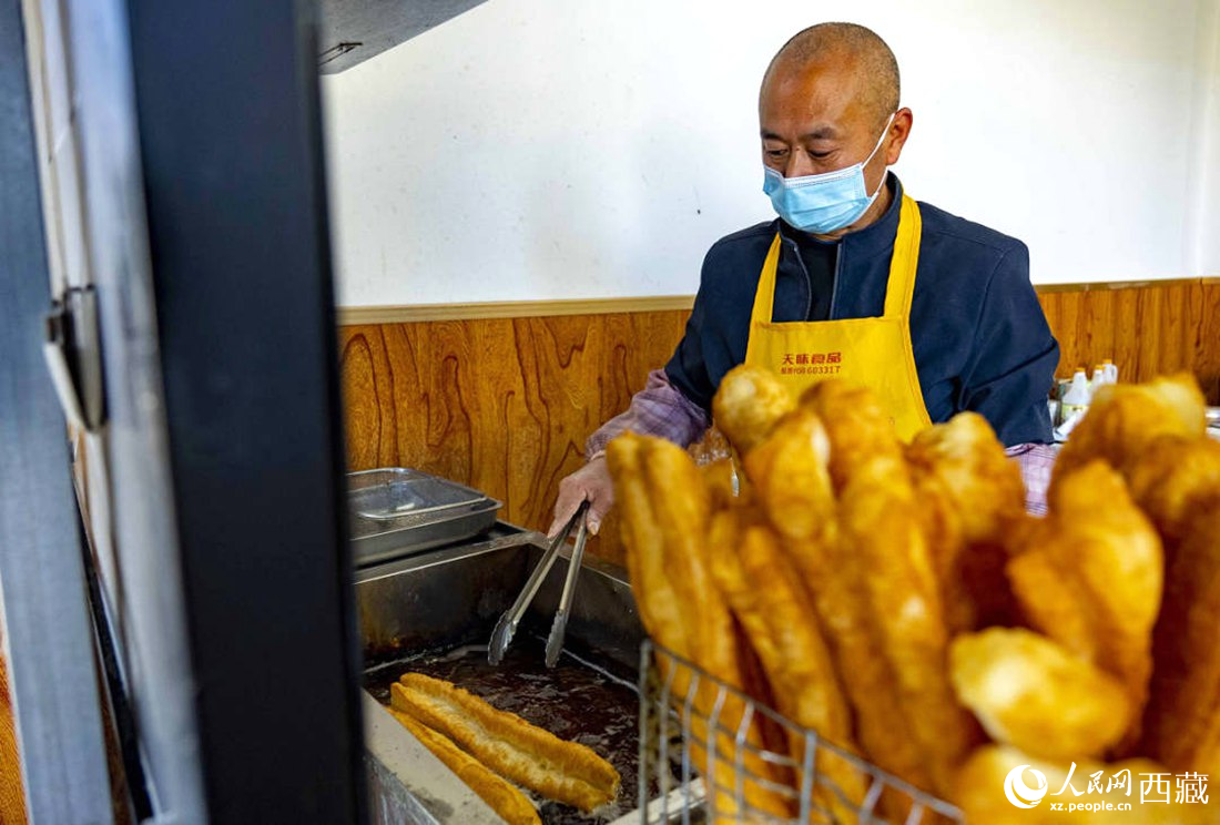 早餐店老板正在炸油條。人民網(wǎng) 次仁羅布攝