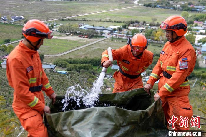 技能大練兵過程中，消防員在陡坡上向蓄水池注水。　李國(guó)燾 攝