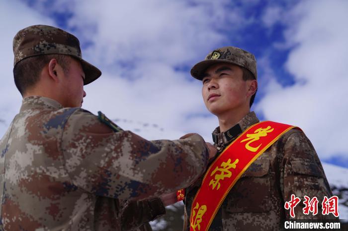 排長王朝偉(圖左)給退伍老兵佩戴大紅花。　西藏山南軍分區(qū)某團供圖