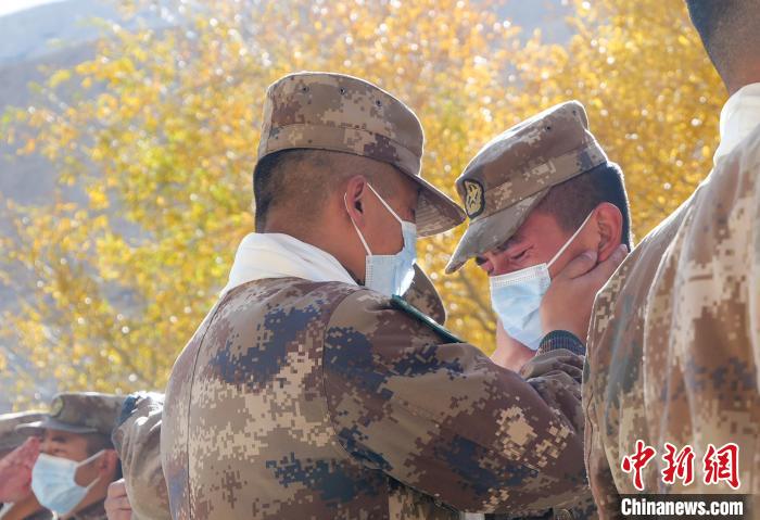 圖為什布奇邊防連退伍老兵與戰(zhàn)友相擁而泣，依依惜別。　徐昌成 攝