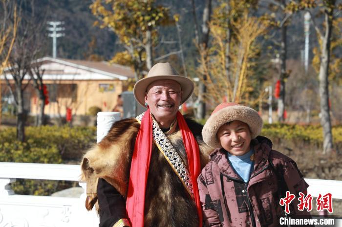 圖為林芝市巴宜區(qū)布久鄉(xiāng)仲果村村民桑杰與孫子一起參加藏歷新年活動?！埩?攝