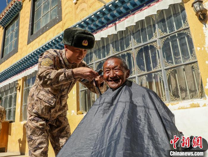 圖為阿里軍分區(qū)某邊防團官兵為駐地群眾理發(fā)迎藏歷新年?！〉┰鰝愔?攝