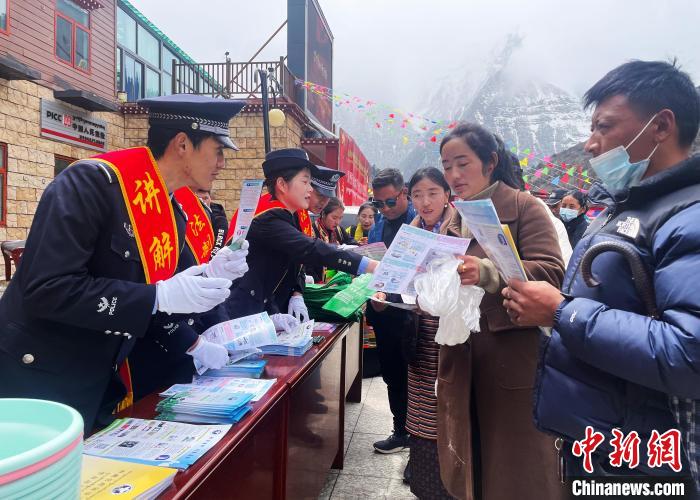 圖為山南玉麥邊境派出所民警為轄區(qū)群眾發(fā)放法律知識宣傳單?！＄婗?　攝