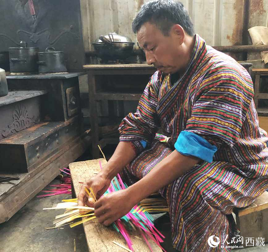 門巴族漢子愛明正在編織藤竹品。