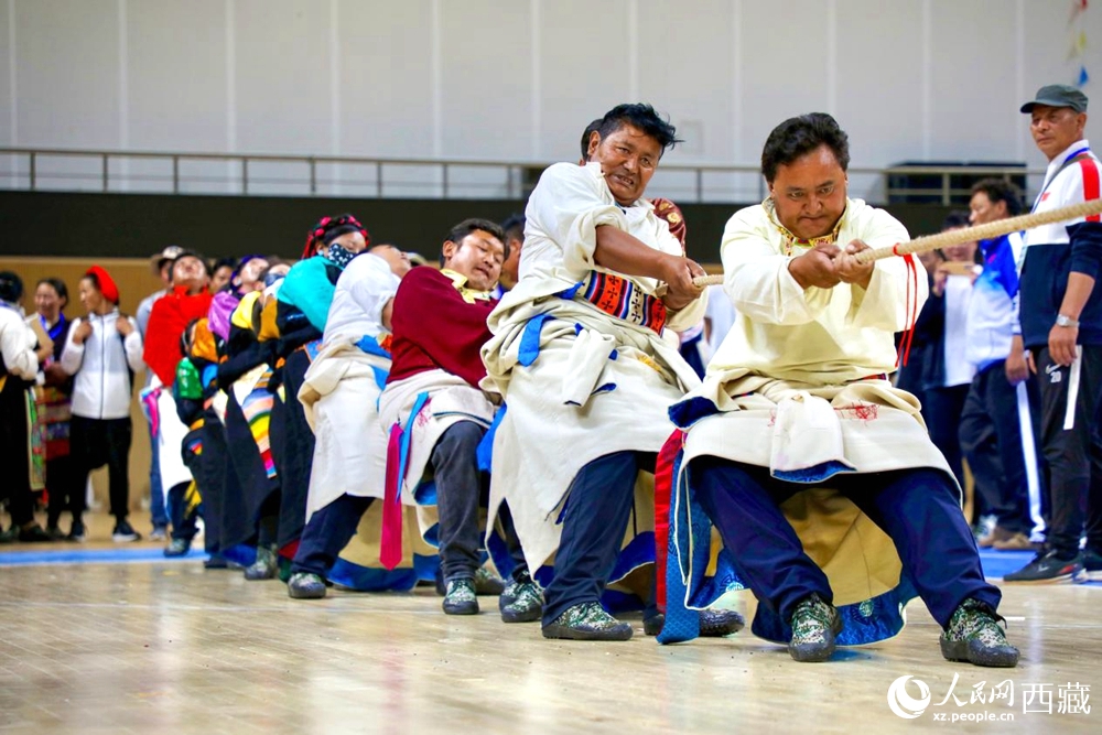 身著民族服裝的農(nóng)牧民選手在拔河比賽現(xiàn)場。